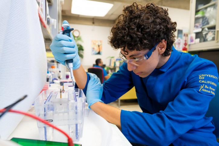 Amin carefully uses a syringe to fill tubes