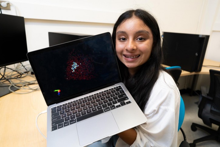 Avni holds up a laptop