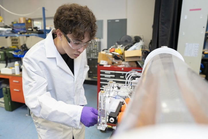 Calvin makes adjustments to a machine in the lab.