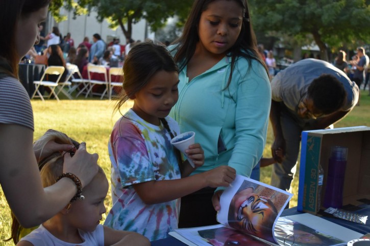 Children look through book of face painting options
