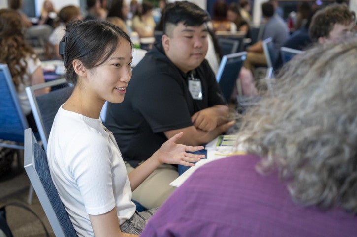 Credential students sit around a round table and talk to one another.