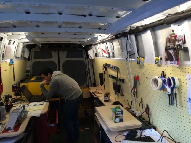An interior shot of the van interior, with pegboard tools and laser cutter in view. 