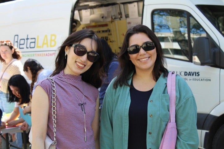Two students pose together in front of the Beta Lab van.