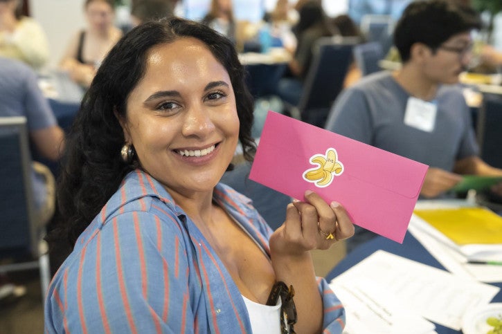 A credential student smiles while holding a letter she wrote to her future self.