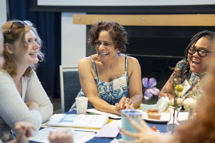 Teacher Education Associate Chair Lola Muldrew speaks with several new credential students.