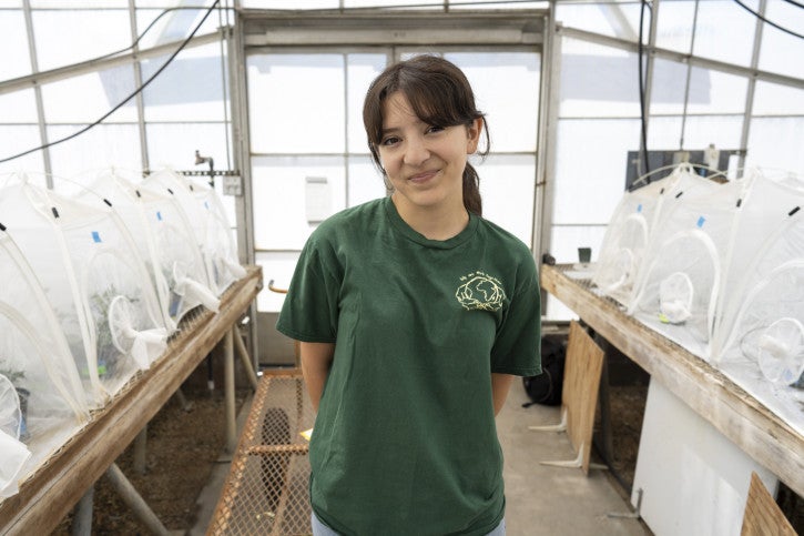 Lola smiles in the greenhouse.