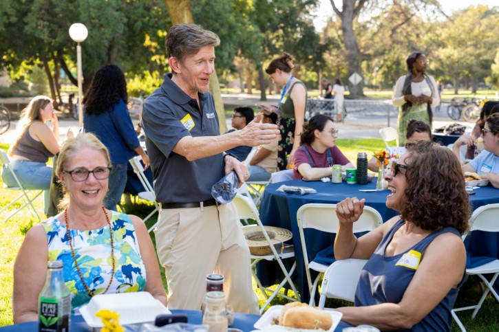 Dean Smith talks to staff at their table