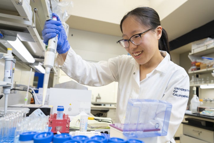 Sophia L. fills small vials using a pipette.