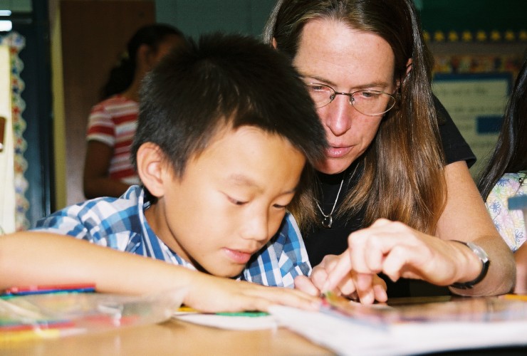 Rebecca Ambrose working with elementary school student