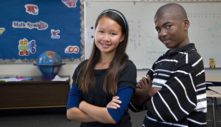 Two elementary students posing for a photo in their classroom