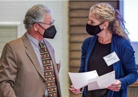 Two professionals wearing medical masks conversating