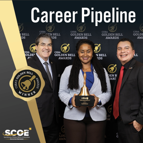Shanine Coats stands in between her two colleagues, holding the Golden Bell Award.