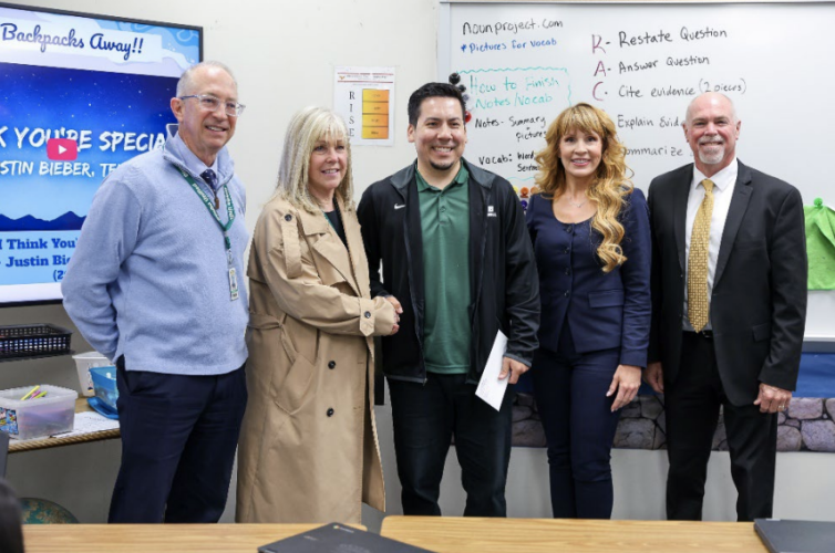 Michael Bedoya poses for a photo with school and district leadership.