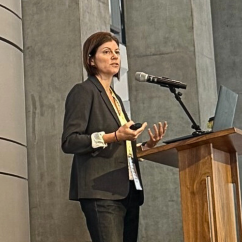 Nicole Sparapani stands at a podium and speaks into a microphone.