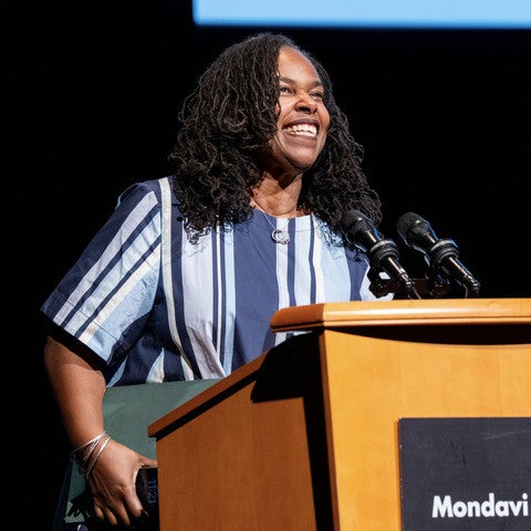 Renée Watson stands at a podium and speaks into a microphone. On the podium is a sign that reads "Mondavi Center."