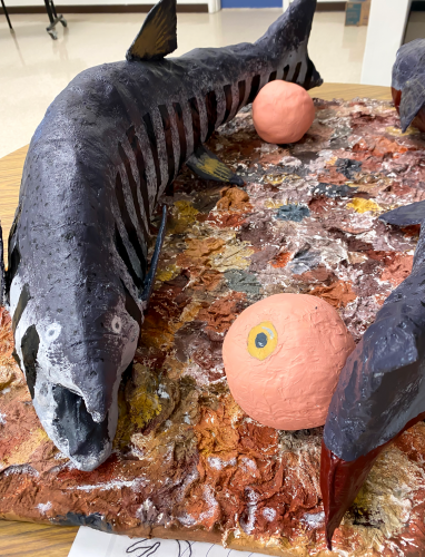 A papier mache model of two salmon swimming in circles.