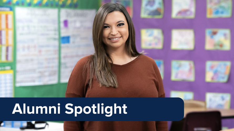 A banner that reads "Alumni Spotlight" is placed over an image of a woman wearing a brown sweater and standing against a classroom background.