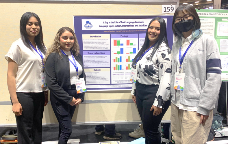  Andrea Sanchez, Lizbeth G Vazquez, Karen Adriana Gomez, and Young Wu pose for a photo in front of their poster which reads "A Day in the Life of Dual Language Learners: Language Input-Output, Interactions, and Activities