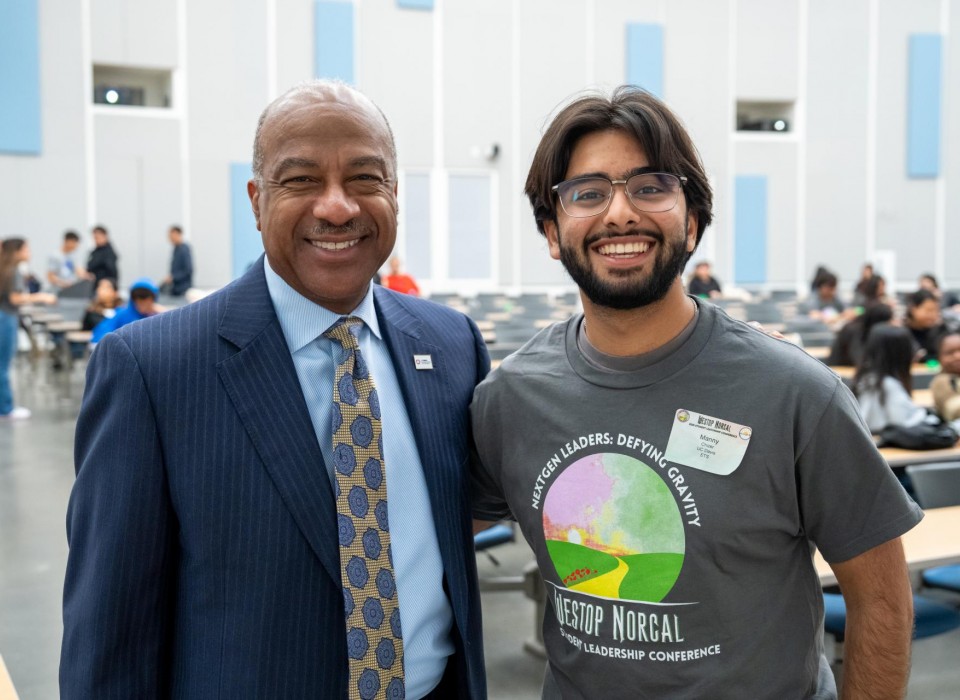 Chancellor Gary May poses for a photo with a student wearing a WESTOP shirt.