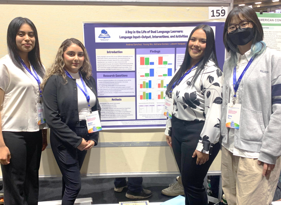 Andrea Sanchez, Lizbeth G Vazquez, Karen Adriana Gomez, and Young Wu pose for a photo in front of their poster which reads "A Day in the Life of Dual Language Learners: Language Input-Output, Interactions, and Activities