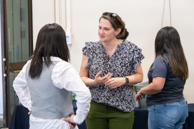 Dr. Cynthia Carter Ching speaks to a PhD student.