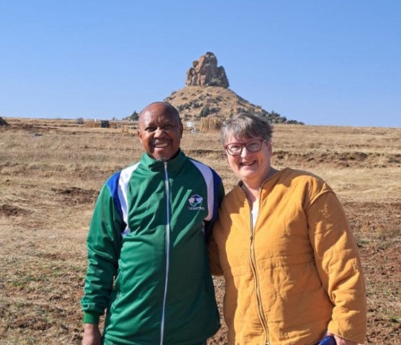 Max and Lauren pose together in Lesotho with a mountain in the background.